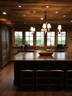 a large kitchen with an island and wooden cabinets in the center, along with two bar stools