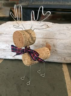 a wine cork deer with a bow on its antlers