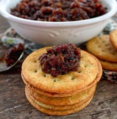 bacon jam on top of crackers in front of a bowl