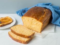 a loaf of bread sitting on top of a white plate next to a slice of bread