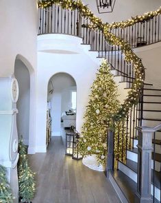 a staircase decorated for christmas with lights and garland on the banisters in front of it