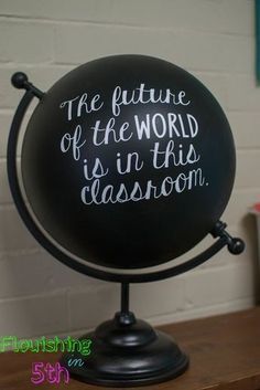 a black globe with writing on it that says the future of the world is in this classroom