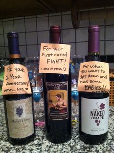 three bottles of wine sitting on top of a counter next to each other with notes written on them