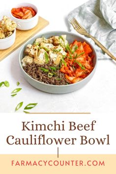 a bowl filled with meat and vegetables on top of a wooden cutting board next to two bowls