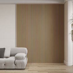 a white couch sitting in front of a wall with vertical striped wood panels on it