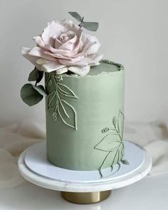 there is a green cake with flowers on it