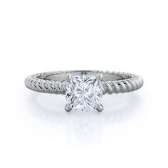 a white gold engagement ring with a cushion cut diamond in the center and twisted band