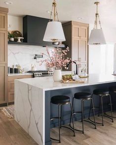 an image of a kitchen setting with bar stools in the center and countertop