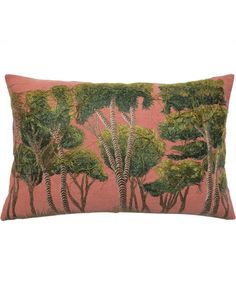 a pink and green pillow with trees on it