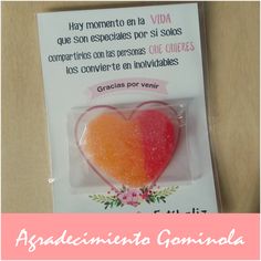 a heart shaped lollipop in a package with spanish text on the front and back