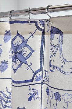 a pair of blue and white curtains hanging from a curtain rod