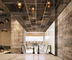 an empty lobby with metal railings and lights on the ceiling is pictured in this image