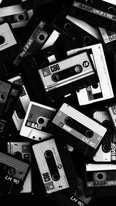 black and white photograph of old cassettes piled on top of each other in the middle