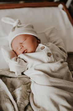 a baby is sleeping in a suitcase with its head tucked under the blanket and it's eyes closed