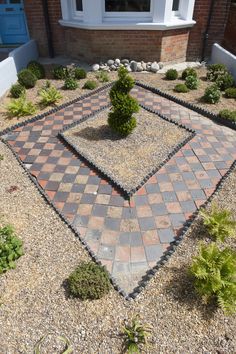 a small garden with rocks and gravel in front of a house