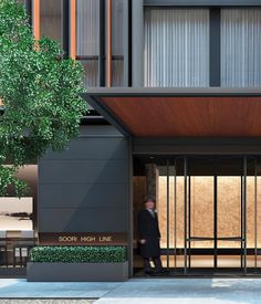 a man is walking out of the entrance to a building with glass doors on both sides