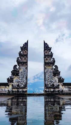 two large gates that are in the middle of a body of water on a cloudy day