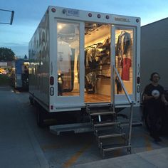 two people are sitting in the back of a moving truck with stairs leading up to it