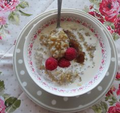 a bowl filled with oatmeal and raspberries on top of a table