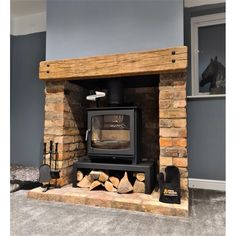 a wood burning stove sitting inside of a living room next to a firewood log