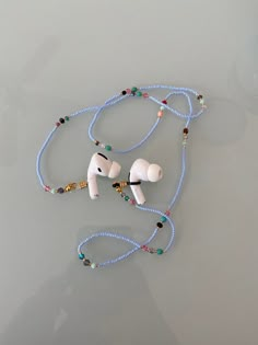 a pair of headphones sitting on top of a blue beaded lanyard with beads