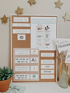 a bulletin board with some writing on it and a potted plant next to it