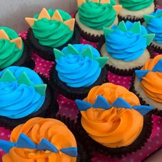 cupcakes with blue and orange frosting in a box