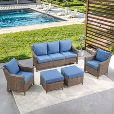 an outdoor patio furniture set with blue cushions next to a swimming pool and wooden fence