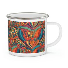 an orange and blue floral design on a white enamel mug