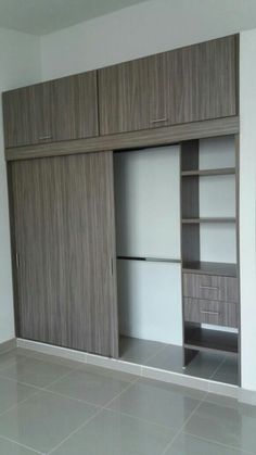 an empty room with wooden cabinets and tile flooring