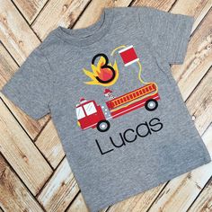 a t - shirt that says lucas on it with a firetruck in the background