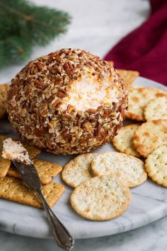 a cheese ball on a plate surrounded by crackers and crackers