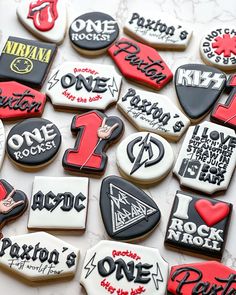 decorated cookies with the names of rock bands are displayed on a white tableclothed surface