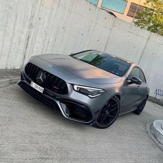 the mercedes amg coupe is parked in front of a concrete wall and has black rims