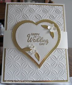 a white and gold heart shaped card with flowers on the front, says happy wedding day