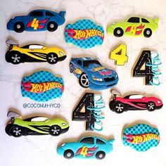 a table topped with lots of cookies covered in different types of car shapes and numbers