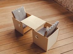 an open cardboard box sitting on top of a wooden floor