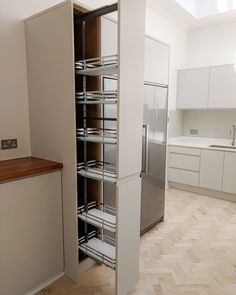 an empty kitchen with white cabinets and stainless steel appliances in the corner, along with hardwood flooring