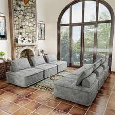 a living room filled with furniture next to a large window and a stone fire place