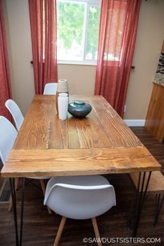 a wooden table with white chairs around it