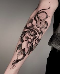 a woman's arm with flowers on it and a snake in the middle of her arm