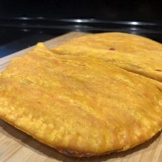 two pieces of bread sitting on top of a wooden cutting board