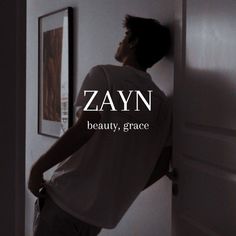 a man standing in front of a door with the word zayn on it's back