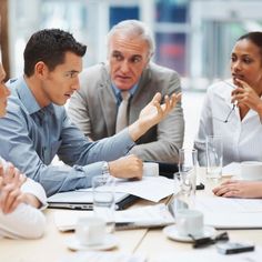 a group of people sitting around a table talking