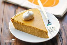 a slice of pumpkin pie on a plate with a fork and napkin next to it