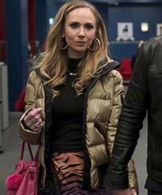 a woman is walking down the street with her hand in her pocket and holding a pink purse