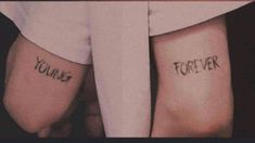 two people with tattoos on their arms and the words young, forever written on them