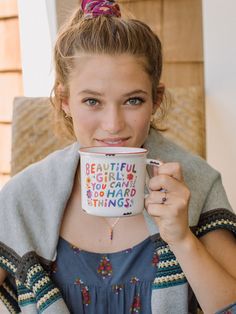 a woman is holding a coffee mug in her hands