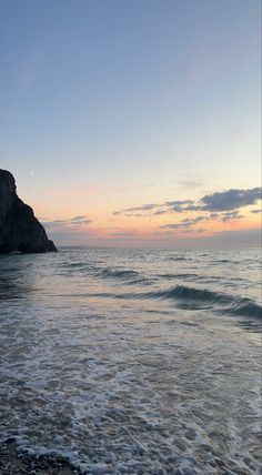 the sun is setting over the water at the beach