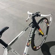 a bicycle parked on top of a parking lot next to a bike rack with wheels